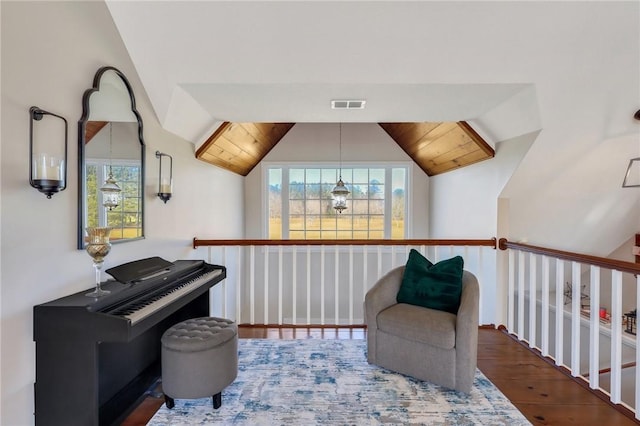 living area featuring lofted ceiling, wood finished floors, and visible vents