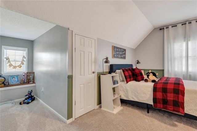 bedroom with baseboards, carpet floors, and lofted ceiling