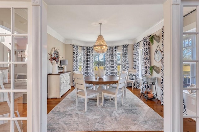 dining room with wood finished floors and ornamental molding