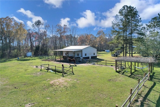 view of yard with an outdoor structure, fence, and an outbuilding