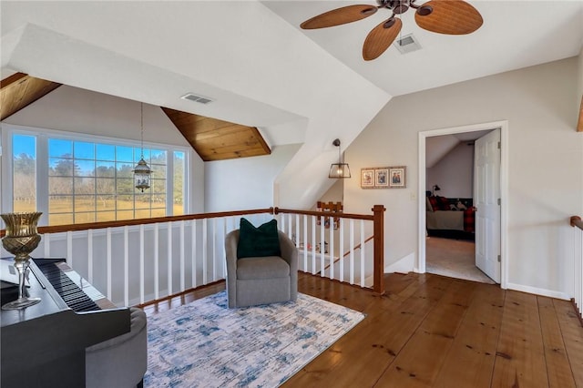 living area with visible vents, an upstairs landing, hardwood / wood-style flooring, and vaulted ceiling