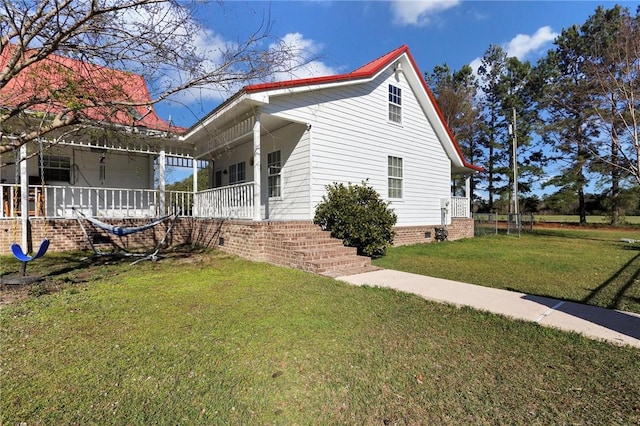 view of side of property with crawl space, a lawn, and a porch