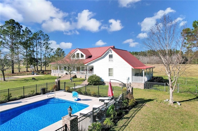 view of swimming pool featuring a patio, fence, a lawn, and a fenced in pool