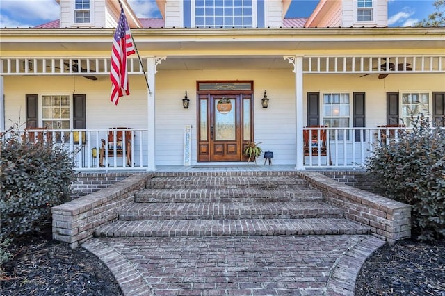 view of exterior entry with metal roof and covered porch