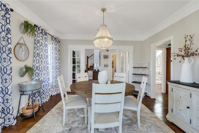 dining area featuring crown molding, dark wood-type flooring, and a chandelier