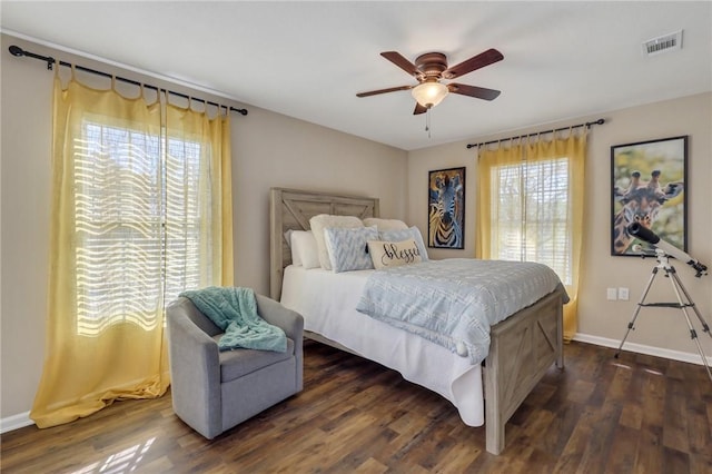 bedroom with multiple windows, dark wood-style floors, and visible vents