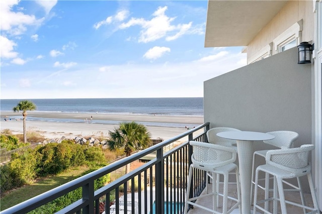 balcony with a water view and a beach view