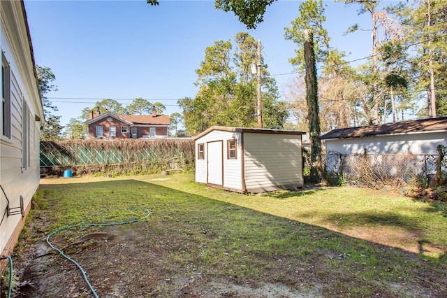 view of yard featuring a fenced backyard, an outdoor structure, and a storage shed