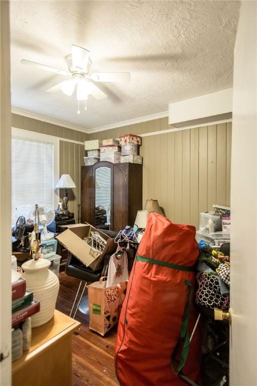 bedroom with crown molding, wood finished floors, and a ceiling fan