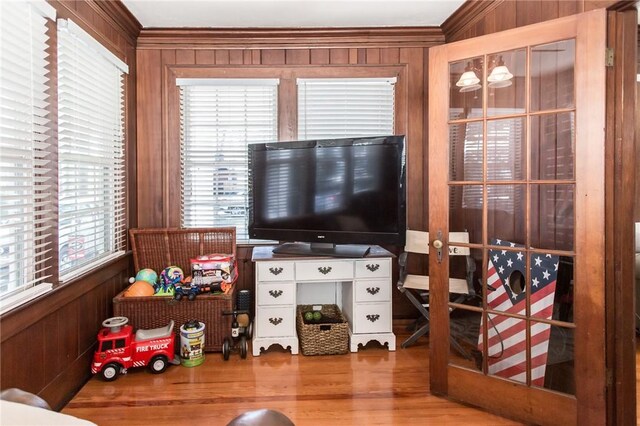 interior space featuring crown molding, wood walls, and wood finished floors
