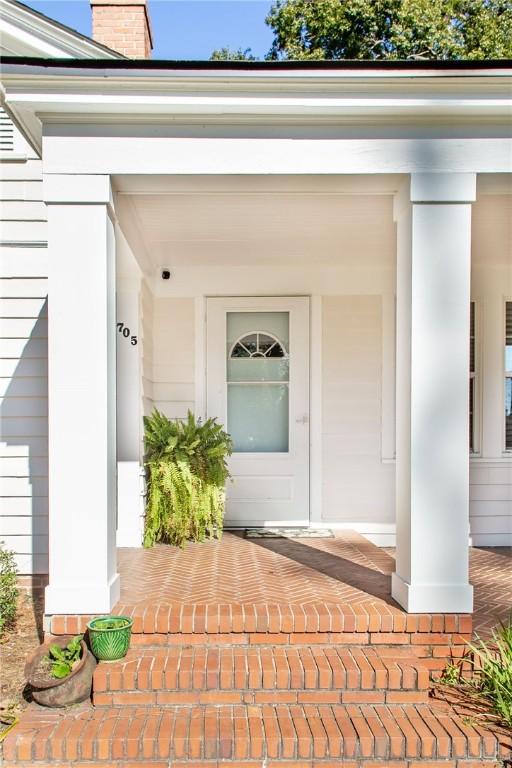 entrance to property with a chimney and covered porch