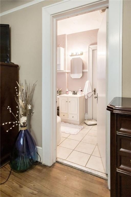 bathroom with vanity, crown molding, and wood finished floors
