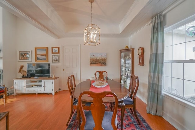 dining room featuring baseboards, an inviting chandelier, light wood-style flooring, crown molding, and a raised ceiling