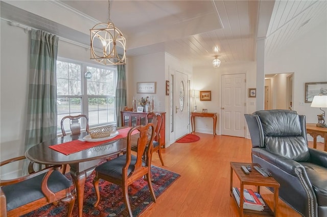 dining space featuring an inviting chandelier, crown molding, and light wood-style floors