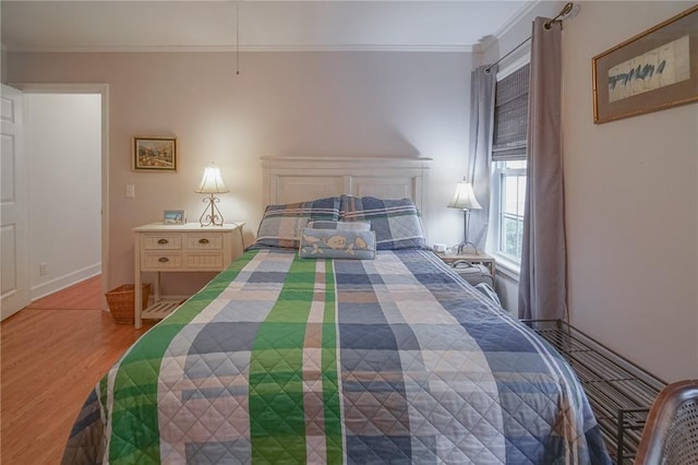 bedroom with wood finished floors and crown molding