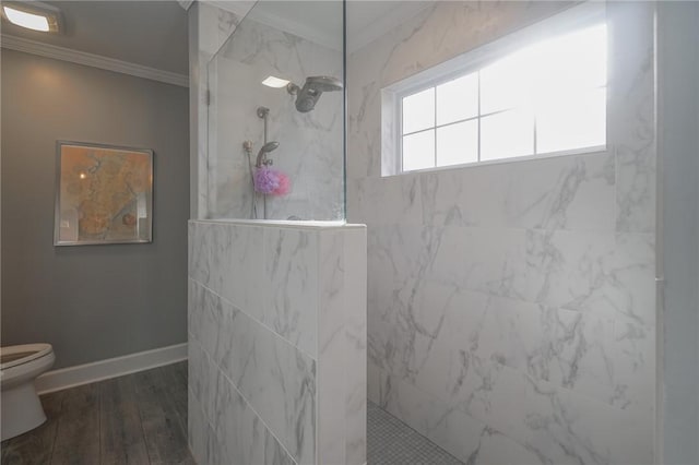 bathroom with wood finished floors, baseboards, a marble finish shower, ornamental molding, and toilet