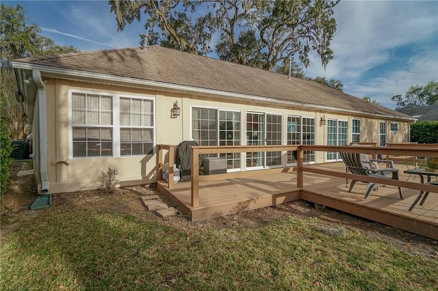 back of property featuring a wooden deck, roof with shingles, and central AC