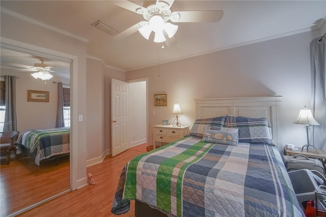 bedroom with visible vents, light wood-style flooring, a ceiling fan, ornamental molding, and baseboards