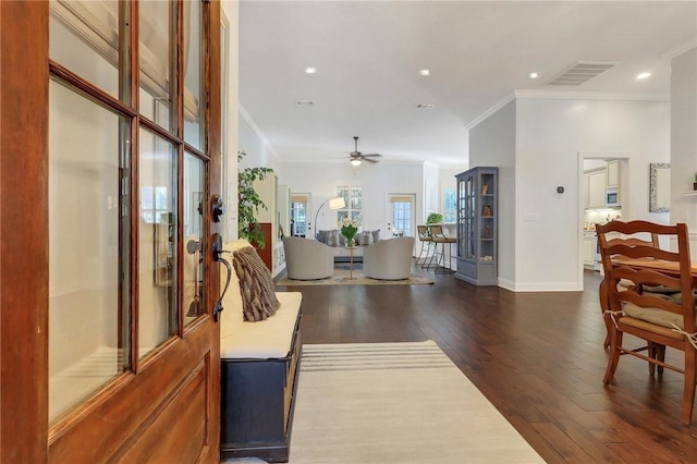 foyer entrance with crown molding, dark wood finished floors, recessed lighting, visible vents, and baseboards