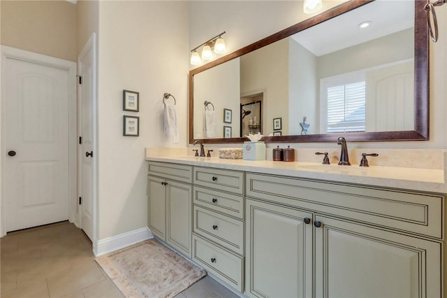 full bathroom featuring double vanity, tile patterned flooring, a sink, and baseboards