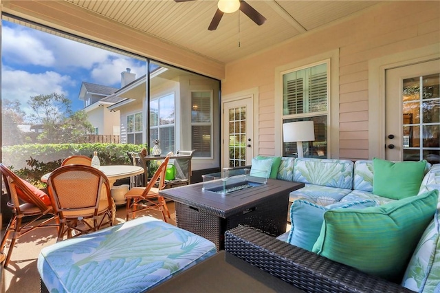 sunroom / solarium with a ceiling fan and wooden ceiling