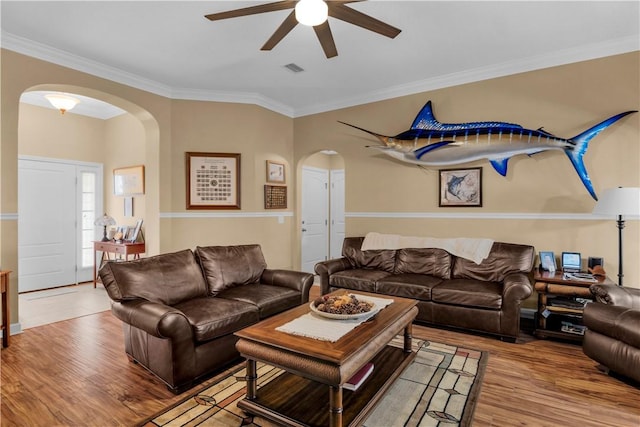 living room with hardwood / wood-style flooring, ceiling fan, and ornamental molding