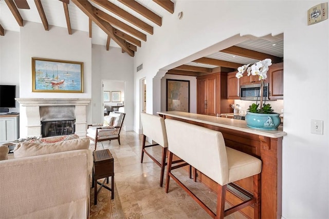 kitchen featuring lofted ceiling with beams and a breakfast bar area