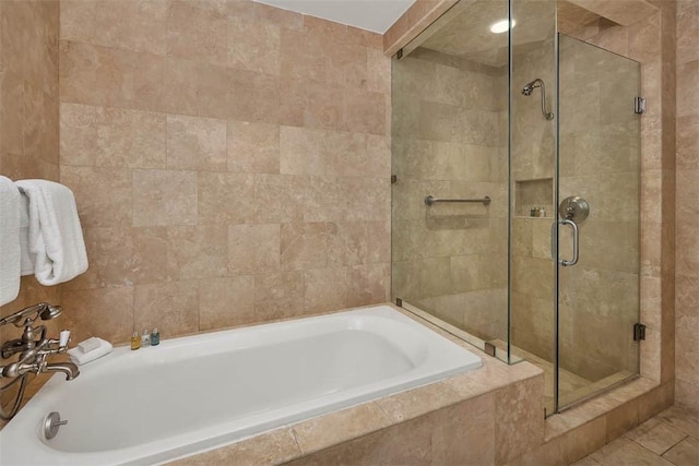 bathroom with tile patterned flooring, tile walls, and independent shower and bath