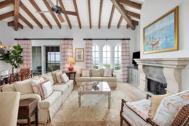 living room featuring beam ceiling, high vaulted ceiling, ceiling fan, and a premium fireplace