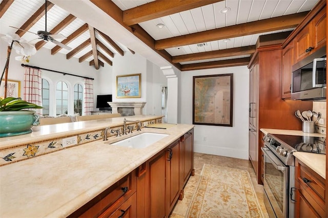 kitchen featuring stainless steel appliances, ceiling fan, sink, light tile patterned floors, and lofted ceiling with beams