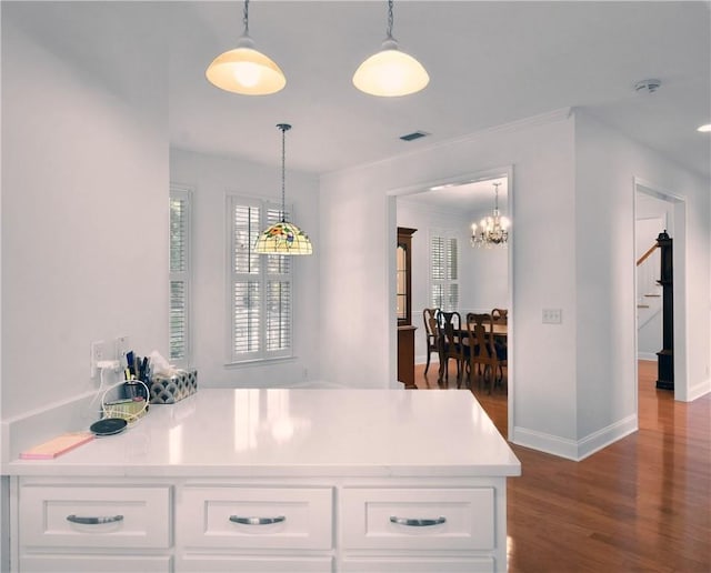 103 Bellrain Ln, Saint Simons Island, GA 31522 - kitchen with dark wood-style flooring, white cabinetry, a chandelier, decorative light fixtures, and light countertops