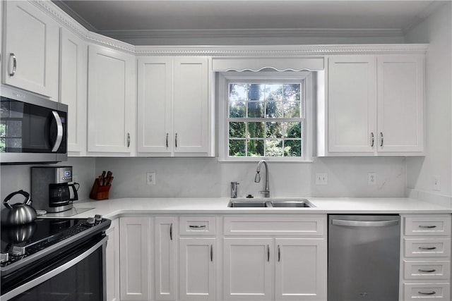 103 Bellrain Ln, Saint Simons Island, GA 31522 - kitchen featuring appliances with stainless steel finishes, white cabinets, light countertops, and ornamental molding