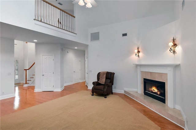103 Bellrain Ln, Saint Simons Island, GA 31522 - unfurnished room with a towering ceiling, wood finished floors, a fireplace, stairway, and ceiling fan