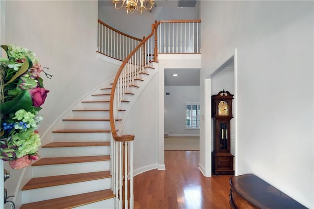 103 Bellrain Ln, Saint Simons Island, GA 31522 - stairs featuring wood finished floors, a chandelier, and a towering ceiling