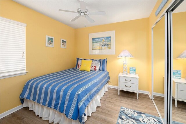 bedroom with a closet, light hardwood / wood-style flooring, and ceiling fan