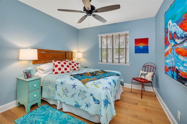 bedroom featuring ceiling fan, baseboards, and wood finished floors