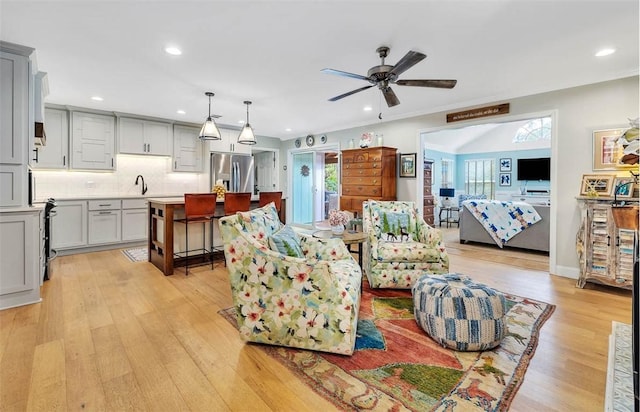 living area featuring light wood-style floors, plenty of natural light, and recessed lighting