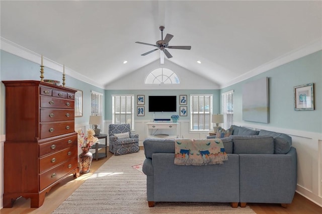 living room featuring light wood-type flooring, a wainscoted wall, ceiling fan, and vaulted ceiling