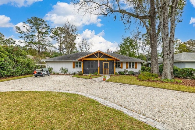 ranch-style house featuring driveway and a front yard