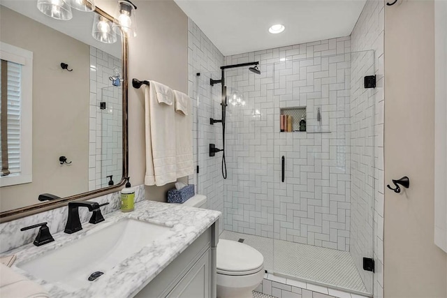 full bath with a stall shower, vanity, and toilet