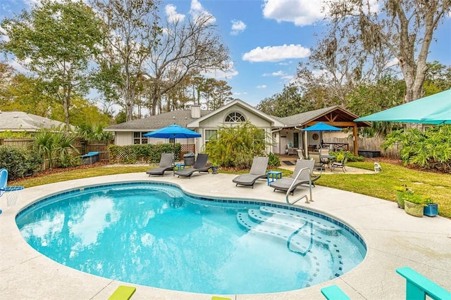 view of swimming pool featuring a yard, a fenced backyard, a fenced in pool, and a patio