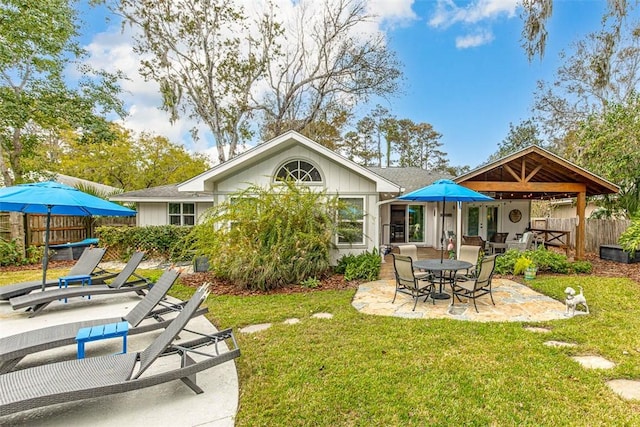 rear view of property with a yard, fence, and a patio