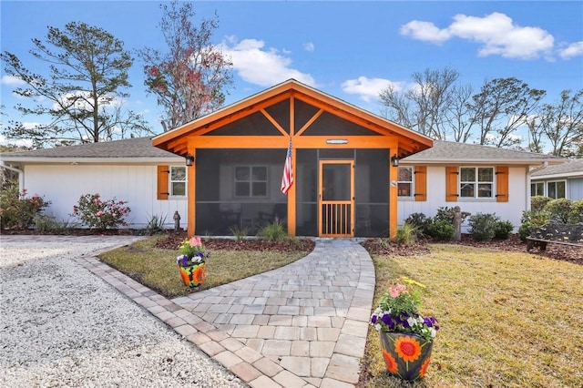 view of front of house with a sunroom and a front lawn