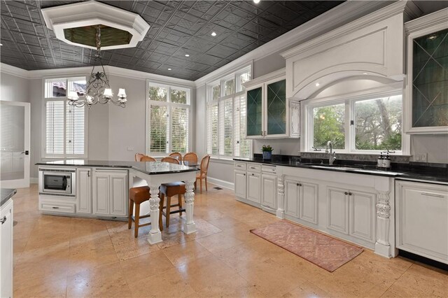 316 Forest Oaks, Saint Simons Island, GA 31522 - kitchen featuring ornamental molding, stainless steel microwave, dark countertops, and an ornate ceiling