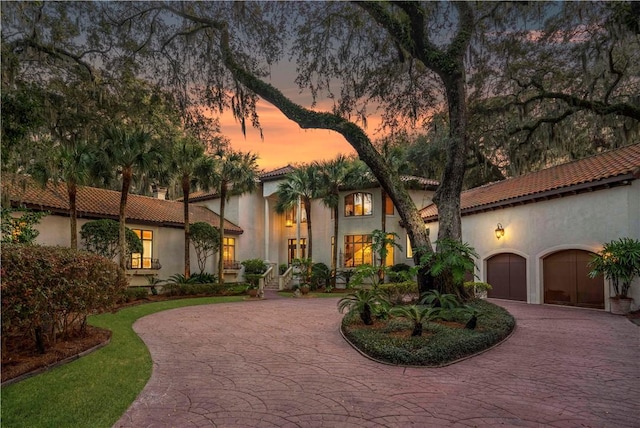 316 Forest Oaks, Saint Simons Island, GA 31522 - mediterranean / spanish-style home featuring curved driveway, a tile roof, and stucco siding