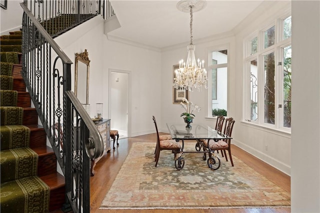 316 Forest Oaks, Saint Simons Island, GA 31522 - dining room with baseboards, stairway, ornamental molding, wood finished floors, and a notable chandelier