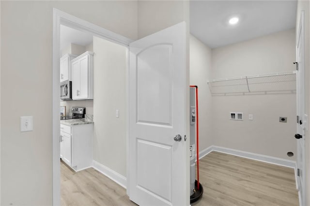 clothes washing area featuring electric dryer hookup, light hardwood / wood-style flooring, and washer hookup