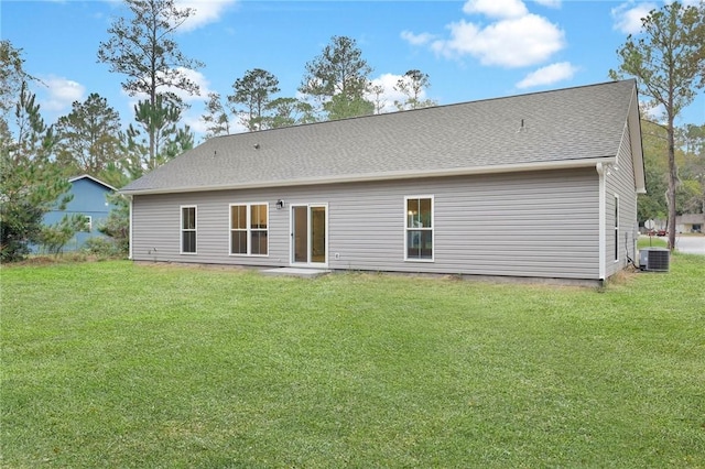 rear view of house featuring a lawn and central air condition unit