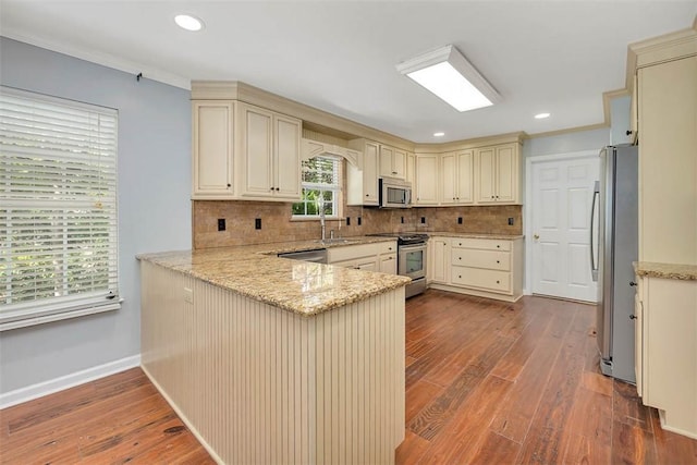 212 Stillwater Dr, Brunswick, GA 31525 - kitchen featuring cream cabinets, a peninsula, dark wood-style flooring, and stainless steel appliances