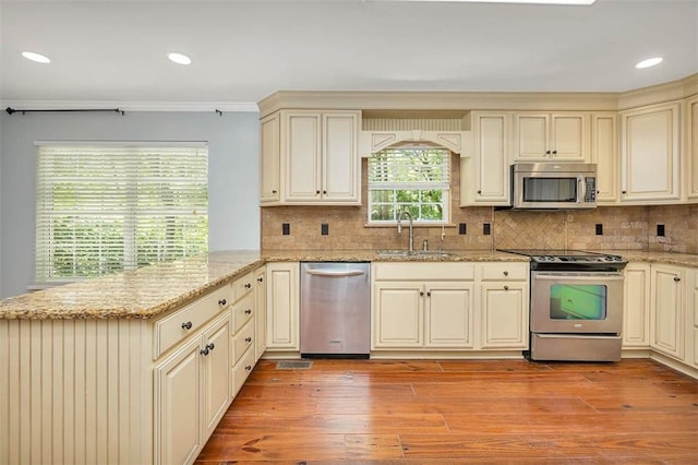 212 Stillwater Dr, Brunswick, GA 31525 - kitchen featuring stainless steel appliances, a sink, light wood-style floors, a peninsula, and cream cabinets
